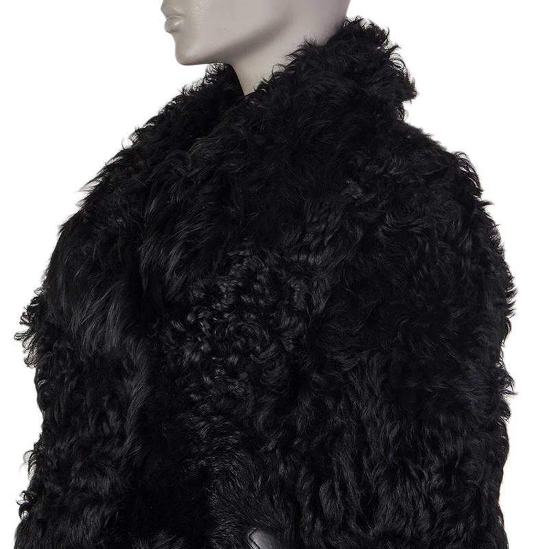 Alaia double breasted jacket in black sheep fur. With wide notch collar and two cinching belts in black leather on the sides. Closes with large buttons in black acetate on the front. Lined in black lambskin (100%). Has been worn and is in excellent