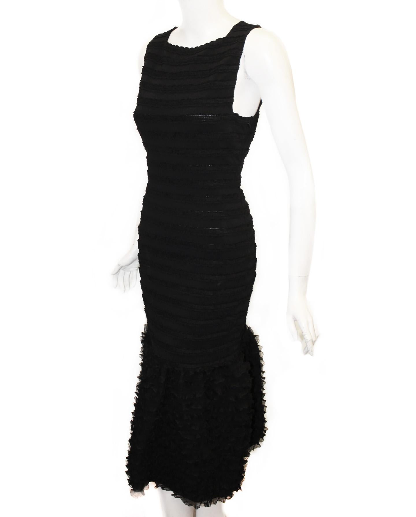 Alaia black sleeveless knit crochet dress incorporates a midi style with layered lace like ruffles creating a wide hem.   Alaia,  
a master sculptor with an unrivaled knowledge of fit and fabric,  molds his clothes perfectly to the female form. 