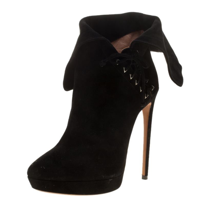 Embodying the utilitarian fashion sense, these ankle boots from Alaia are fabulously made from black suede in Italy. The pair features almond toes with towering 14.5 CM stiletto heels which are supported with covered platforms. The side, lace-up