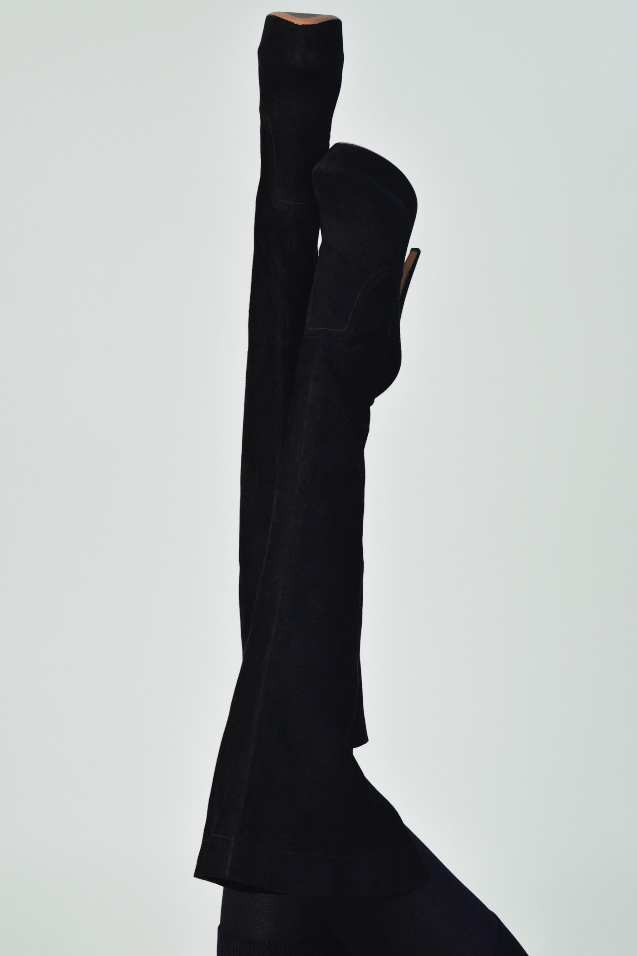 Resurrection Vintage se complace en ofrecer un par de botas con plataforma hasta el muslo de ante negro de Alaia con una amplia abertura en la parte superior de los muslos, ajuste elástico, tacón de aguja y cremalleras en el interior de los tobillos