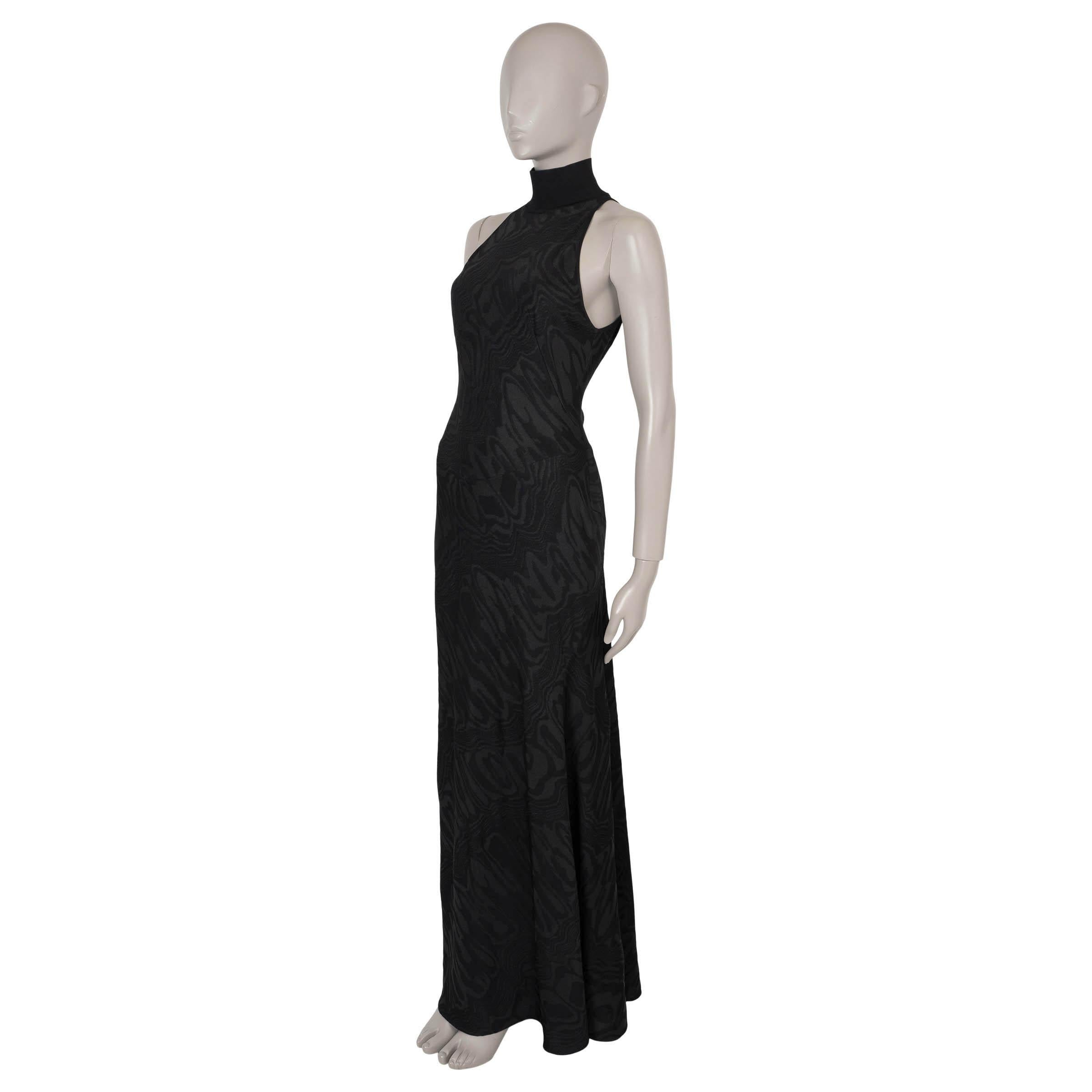 This 100% authentic Alaïa gown in black moiré-jacquard knit viscose (63%), polyester (32%), polyamide (4%), and polyurethane (1%) embodies the designer's signature sculptural elegance. Featuring a fitted halter top with a turtleneck and a flowing