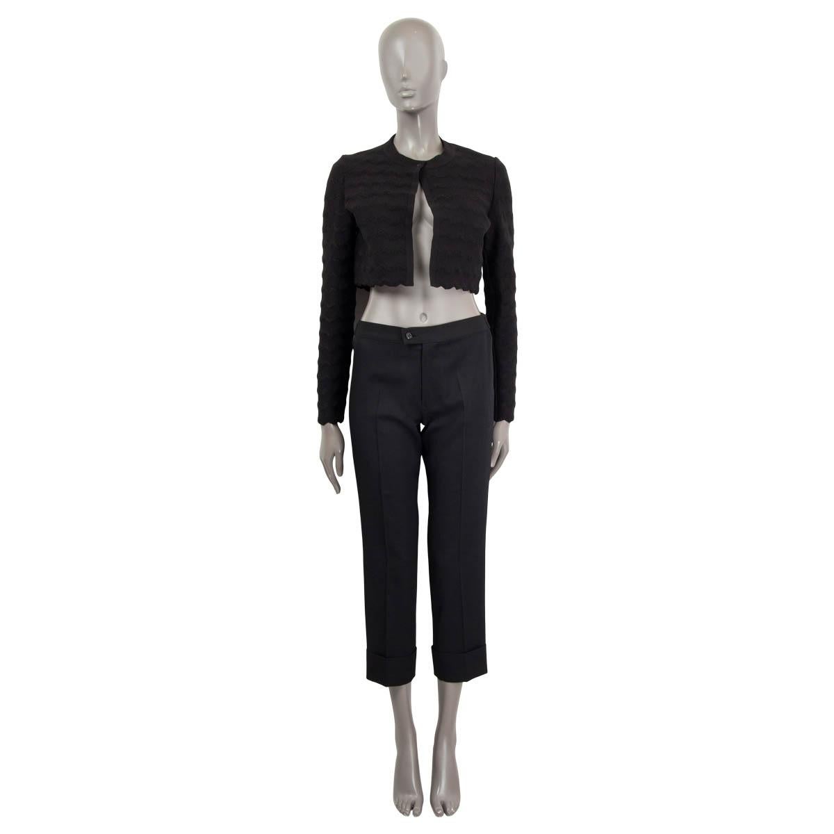 100% authentic Alaïa cropped bolero cardigan in black nylon (47%), wool (44%) and polyester (7%) with long sleeve. Features a zigzag hem at the cuffs and hemline. Opens with one push buttons on the front. Has been worn and is in excellent