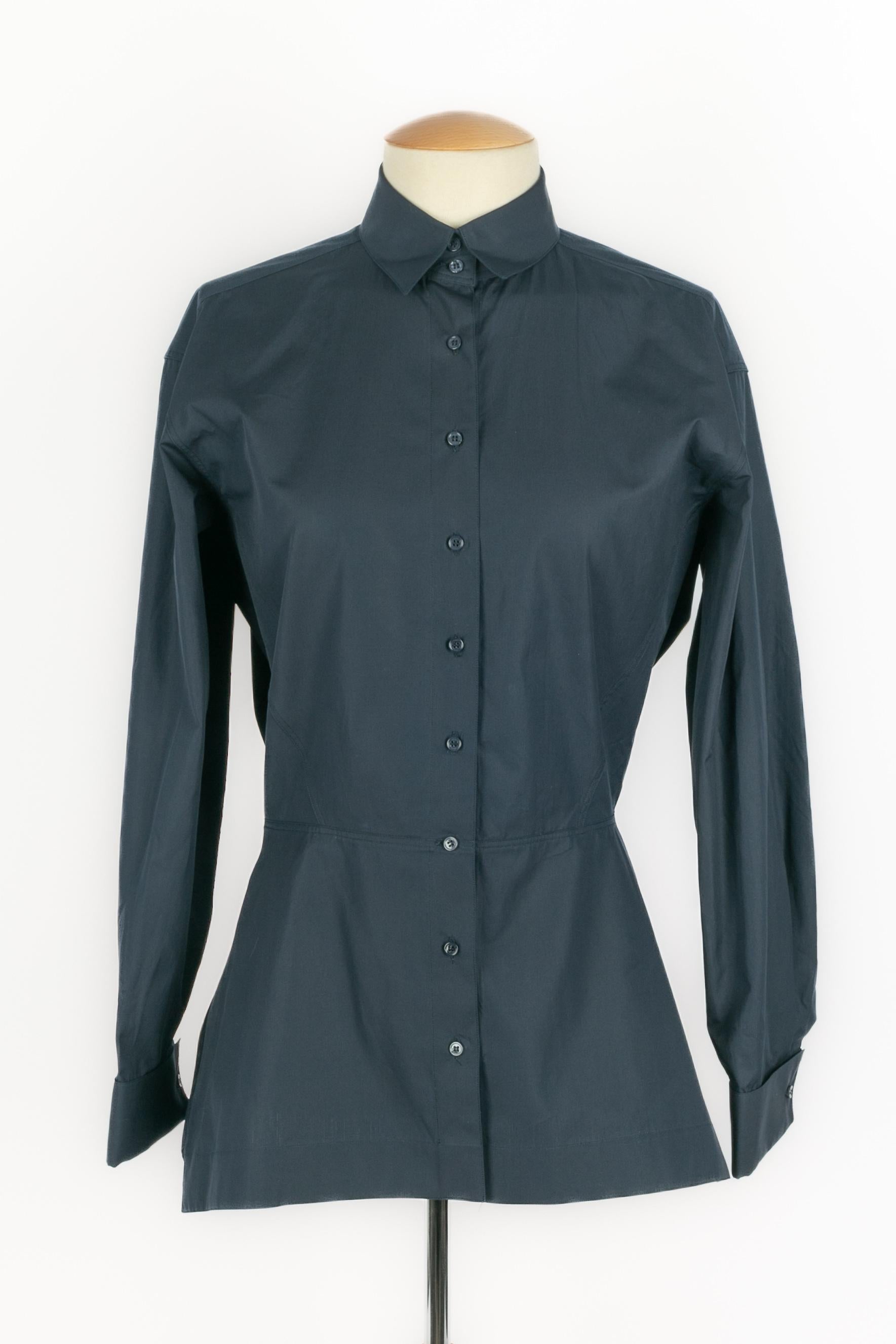 ALAÏA - (Fabriqué en Italie) Chemise queue de pie en coton bleu marine à volants échancrés dans le dos et manches longues. La taille 40IT indiquée correspond à un 36FR.

Condit :
Très bon état.

Dimensions :
Largeur des épaules : 44 cm - Poitrine :