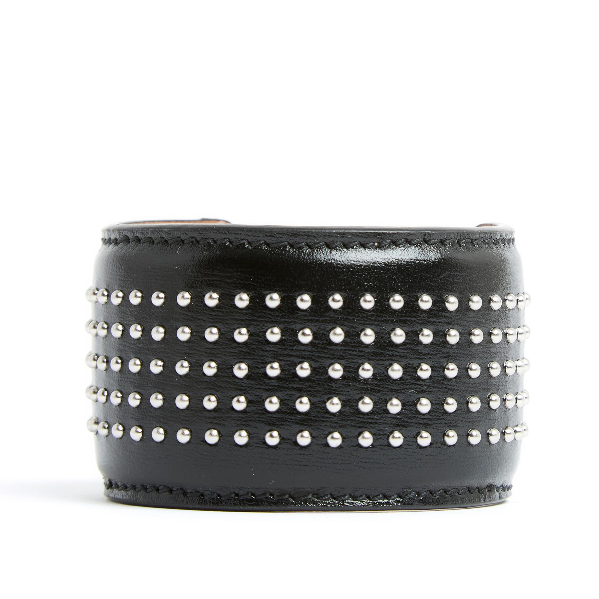 Alaïa open cuff bracelet in smooth black leather decorated with silver metal micro studs, interior of the bracelet lined with black leather. Width of the bracelet seen from above 4 cm, length of the bracelet 14 cm excluding opening for wrist from