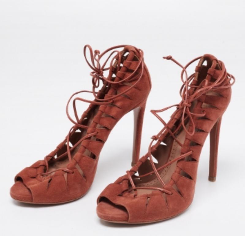 Deliver statement looks with these sandals from Alaia! From their shape and detailing to their overall appeal, they exude sophisticated style. The sandals come crafted from brown-hued suede and are designed with cut, ties, and high heels.