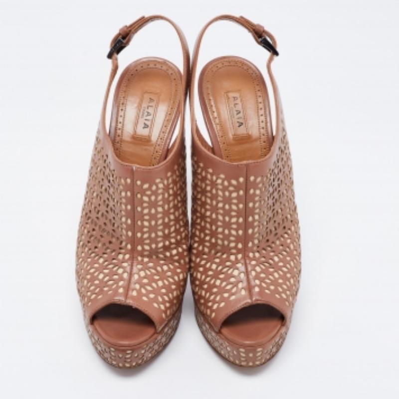 Dale un toque muy chic a tu conjunto con estas impresionantes sandalias Alaia. Fabricados en piel en bonitos tonos, tienen puntera abierta y un diseño recortado en toda su superficie. Se colocan sobre tacones altísimos y se completan con cierres de