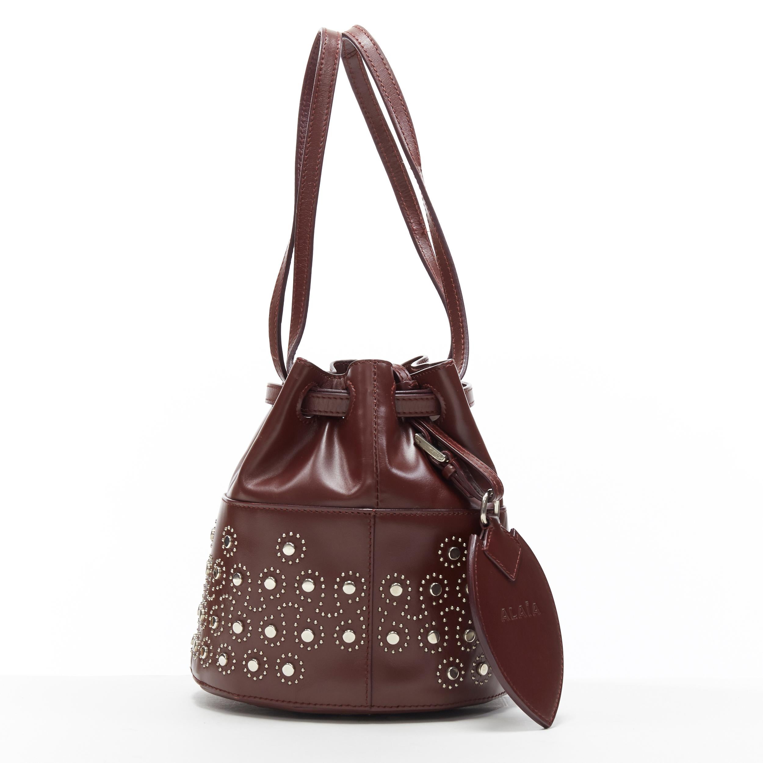 ALAIA burgundy red geometric silver studded drawstring mirror charm bucket bag 
Reference: TGAS/A05207 
Brand: Alaia 
Designer: Azzedine Alaia 
Model: Studded bucket bag 
Material: Leather 
Color: Burgundy 
Pattern: Solid 
Closure: Drawstring 
Made
