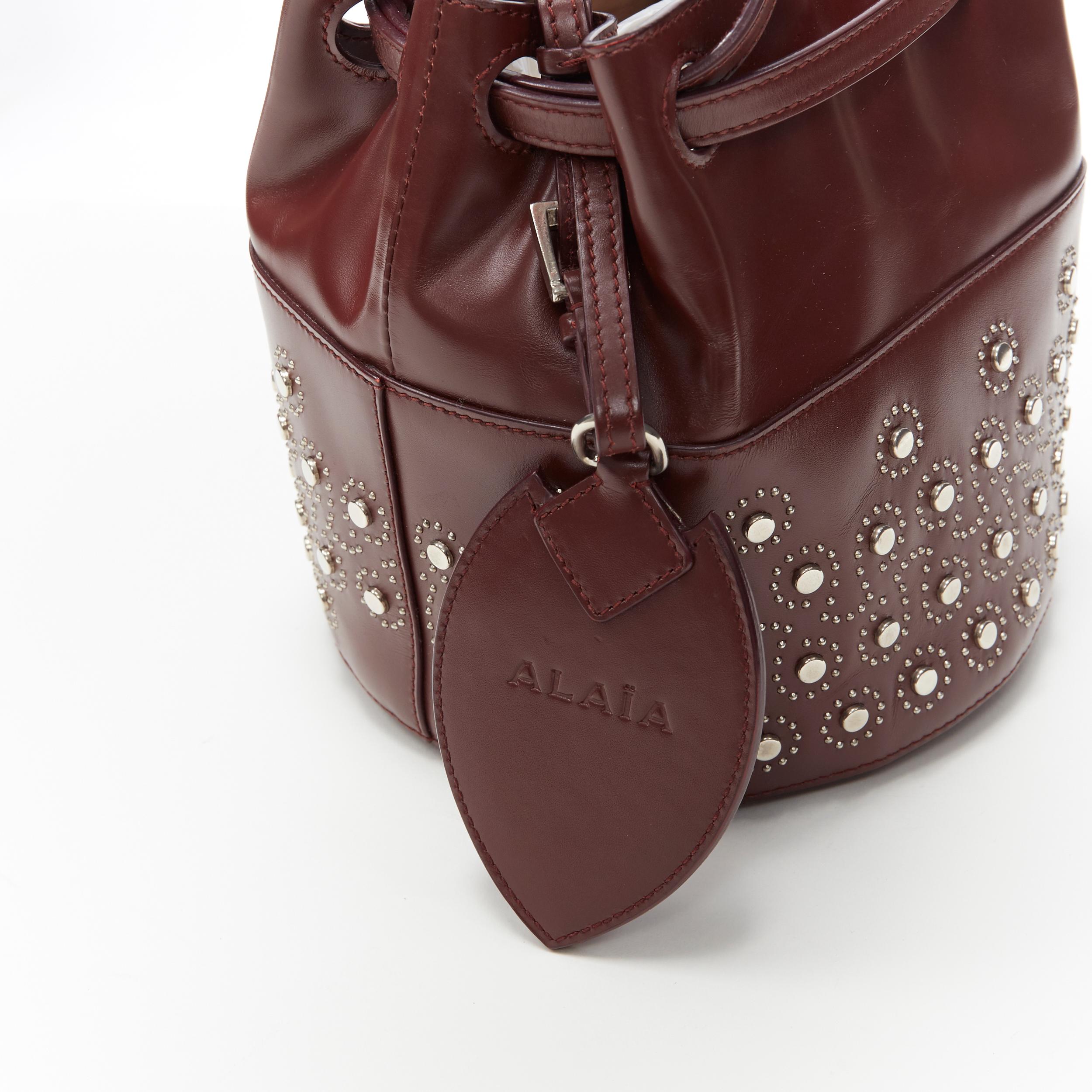 Black ALAIA burgundy red geometric silver studded drawstring mirror charm bucket bag