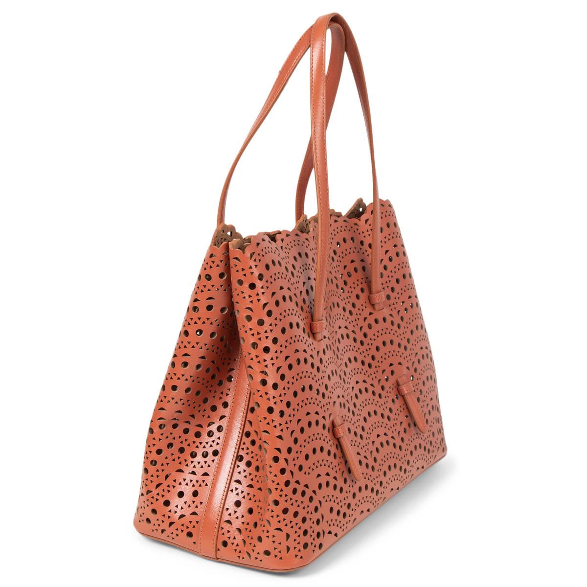 100% authentic Alaïa's Mina 32 tote bag has been crafted in Italy from smooth caramel rose leather that's laser-cut with the Maison's intricate 'Vienne Circulaire' pattern. Opens with a snap-fastening gusseted sides that expand. Comes with a