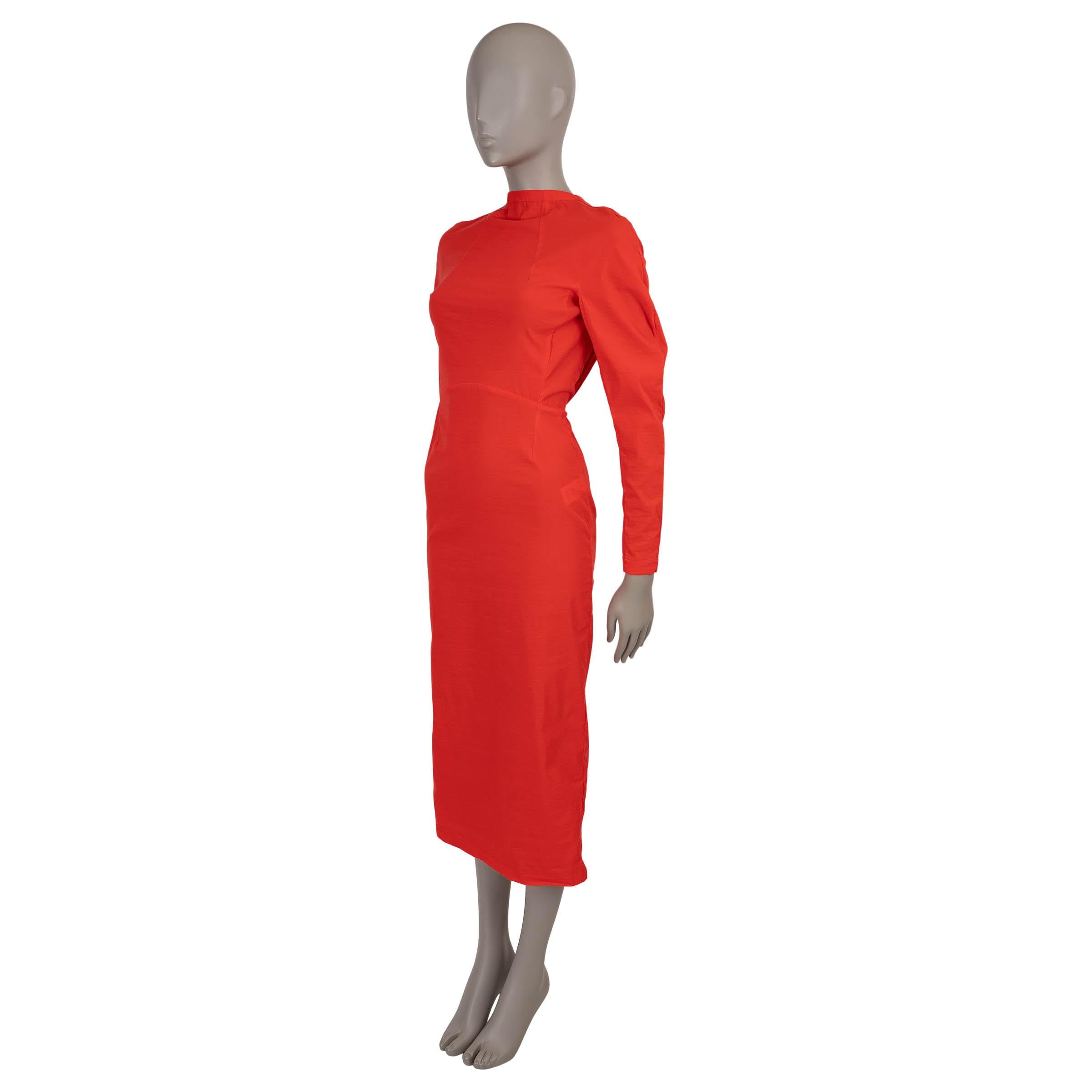 This 100% authentic Alaïa cocktail dress in coral red stretch taffeta viscose (60%), polyamide (33%), and elastane (7%) is a striking blend of sophistication and allure. Designed with a fitted silhouette and midi length, it features a refined mock