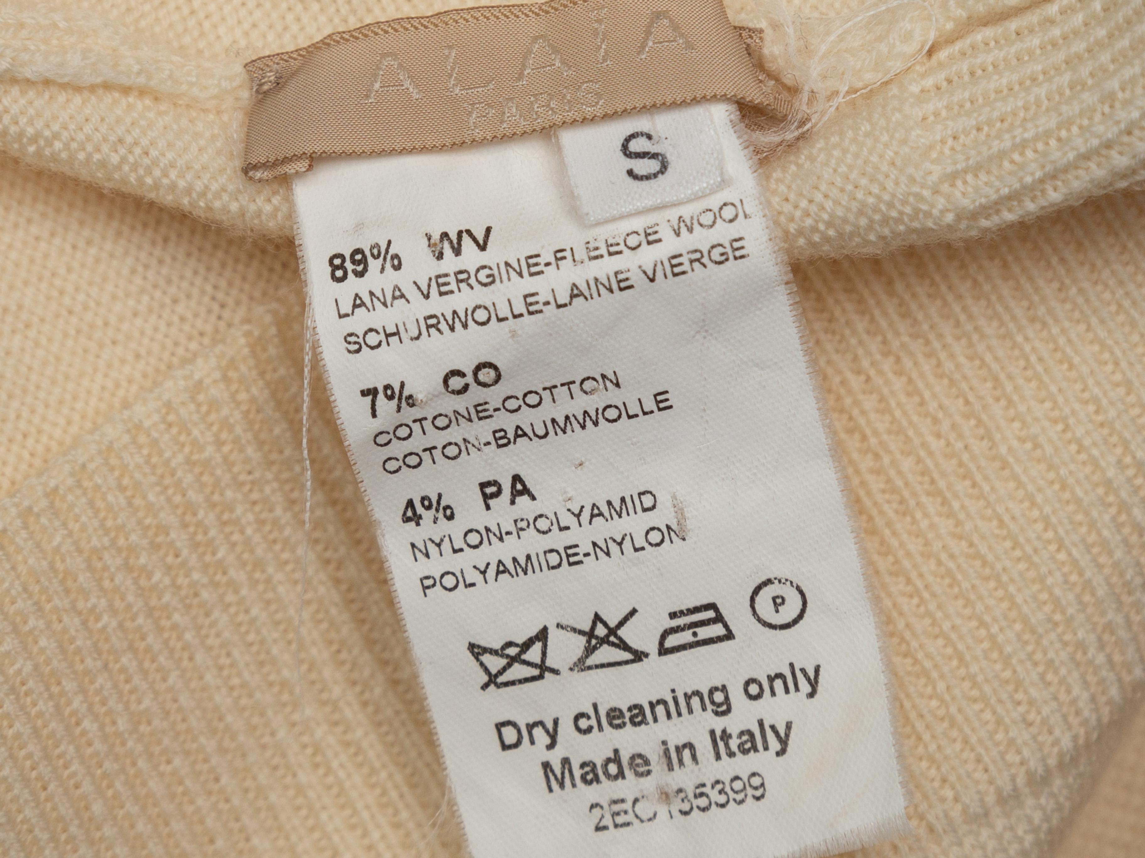 Product details: Cream virgin wool sweater by Alaia. Crew neck. Lace panel accents at bust and sleeves. 32