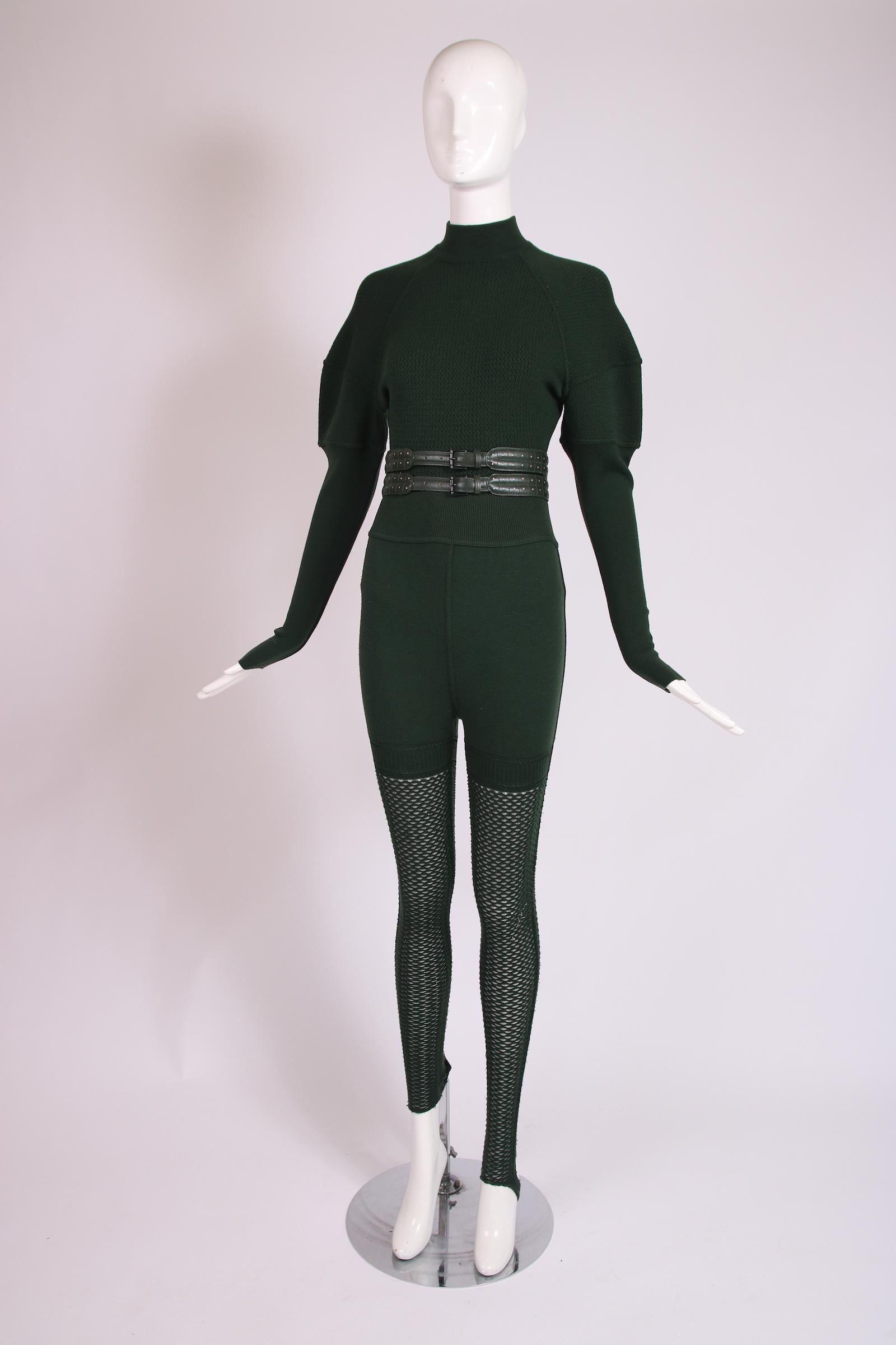 Early 1990's Alaia green stretch wool and rayon blend body suit, stirrup legging and belt ensemble. The body suit combines wool with two distinct weaves and has a mock turtleneck, subtle mutton sleeves and fastens at the crotch with snap closures.