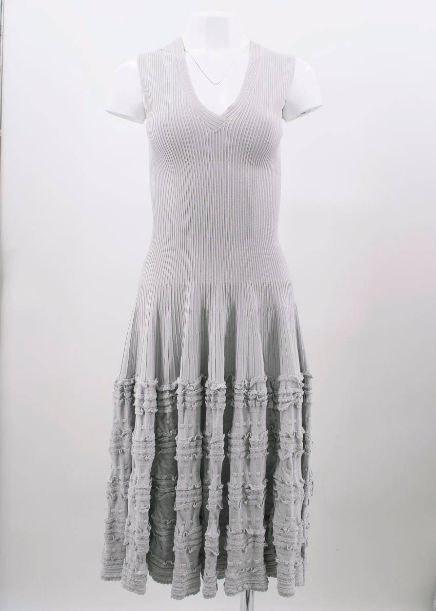 Alaia grey frilled dress. 
Made in France. 

Features a V- neckline and frill detailing on hem of dress. 
Includes zip closure at back. 

Fabric: 83% Viscose, 17% Polyester.

Size: S/US 6. 

Approx: 
Shoulders- 10cm 
Chest- 35cm 
Waist- 31cm