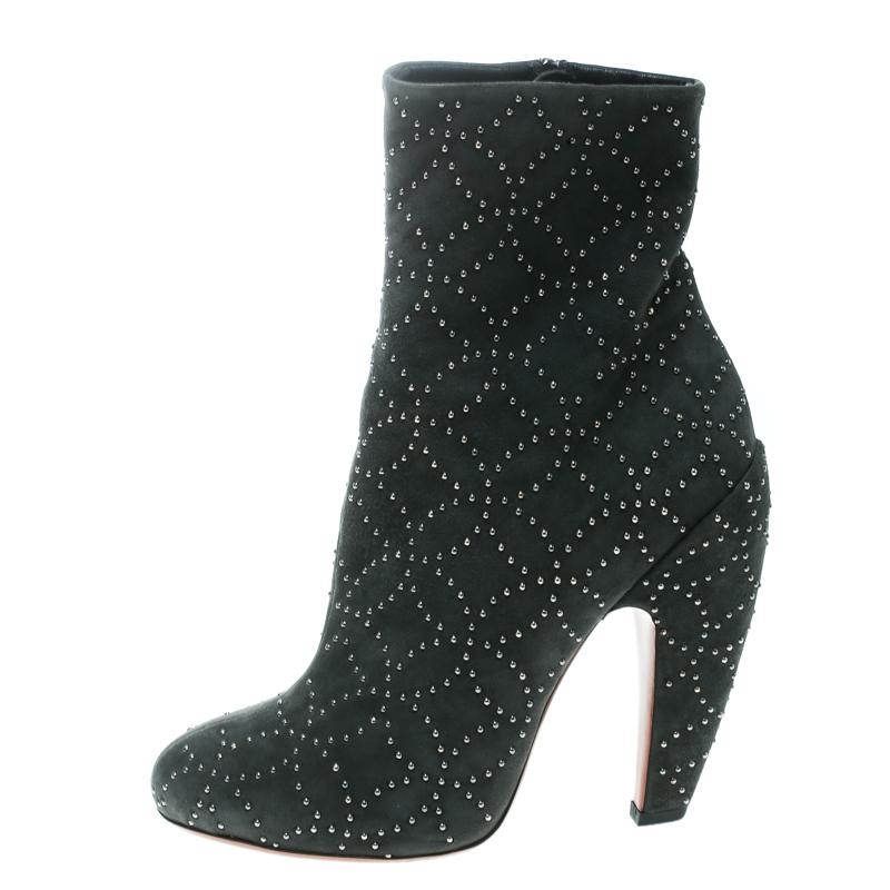 These splendid boots from Alaia have a modern feel with hints of glamor and shine. The grey suede exterior bedecked with gunmetal-tone studs is visually appealing and the shape, with a 13.5cm curved block heel, offers loads of comfort and style. A