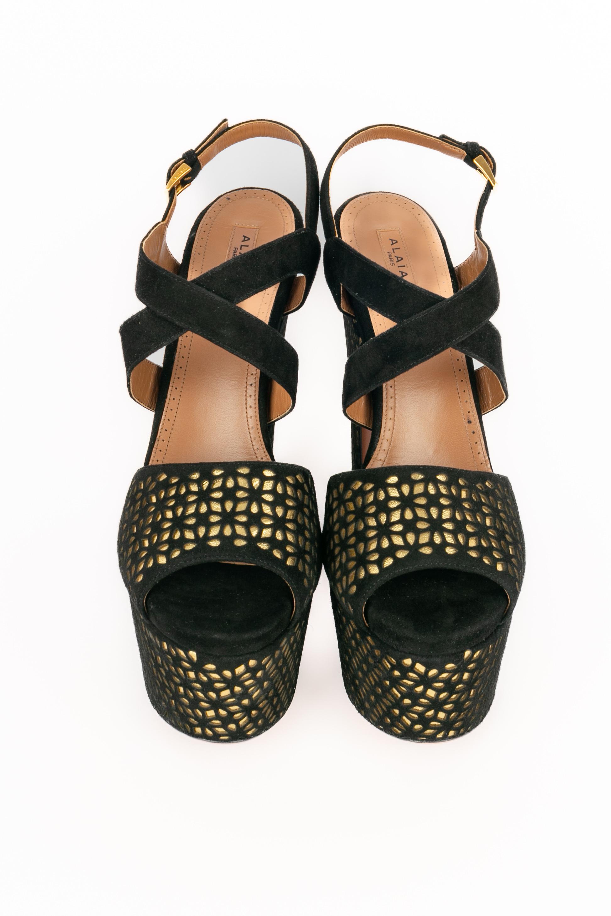 ALAÏA - (Made in Italy) Sandalias de tacón de piel dorada con calados en piel negra. Se indica la talla 40,5FR.

Estado:
Muy buen estado

Dimensiones:
Altura del tacón: 19 cm

SKU:CH114