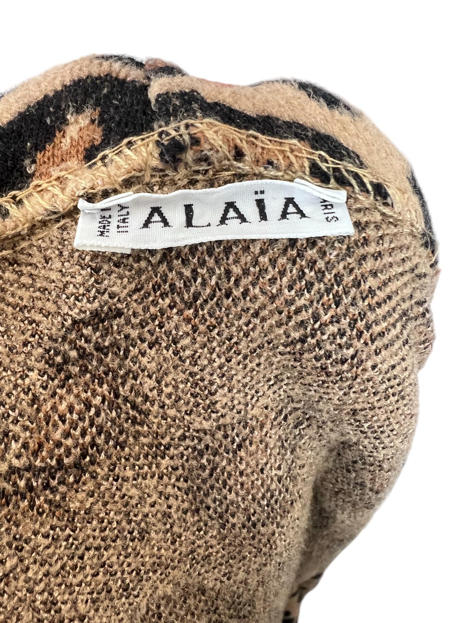This Alaïa Leopard Sweater Jacket is a bold yet effortlessly chic piece, showcasing the brand’s impeccable craftsmanship and attention to detail. Designed with an oversized draped cowl neck, this jacket offers a relaxed yet sophisticated silhouette.