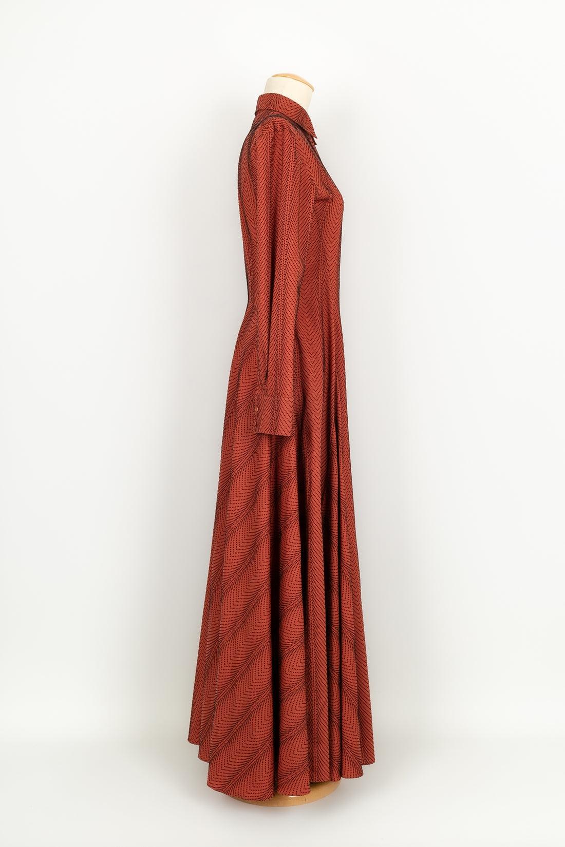 Alaïa - (Fabriqué en Italie) Longue robe évasée en laine marron/orange à pois noirs. Taille 38FR. Attention, deux boutons au niveau des poignets ont été changés.

Informations complémentaires :
Condit : Très bon état.
Dimensions : Largeur des