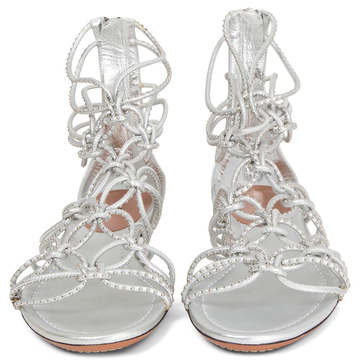 100% authentic Alaïa strappy flat sandals in metallic silver leather embellished with silver-tone studs. Open with a zipper at the heel. Brand new. Come with dust bag. 

Measurements
Imprinted Size	38
Shoe Size	38
Inside Sole	25cm