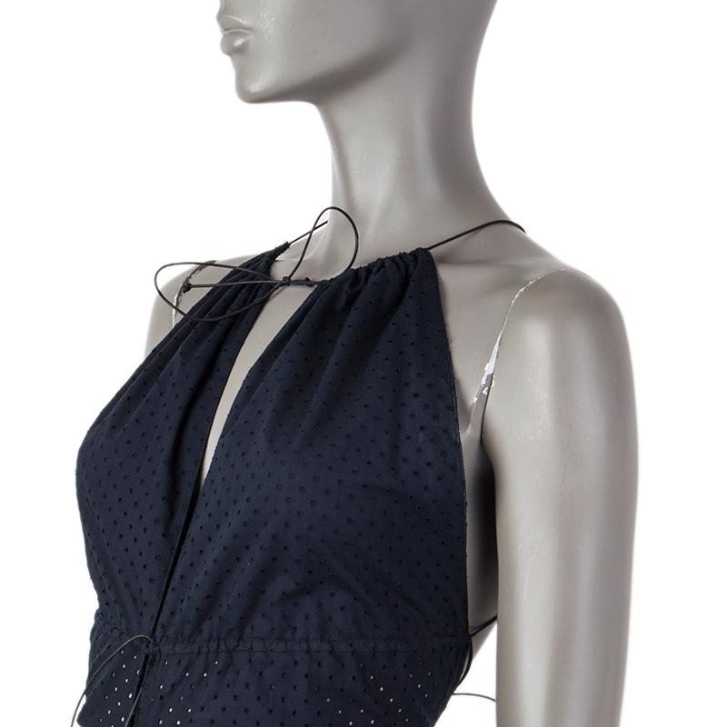 Alaia perforated halter dress in midnight blue cotton (100%). With slit jewel neck, flared skirt open at the front, and drawstring around the neck, under the bust, and around the hips, criss-crossing on the back. Closes with hooks on the front