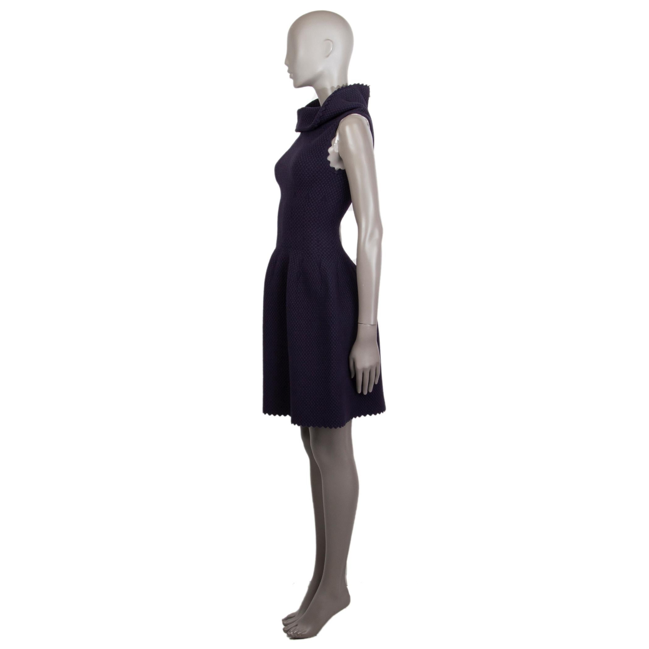 Alaia jacquard-knit flared dress in midnight blue virgin wool (50%), viscose (25%), nylon (20%) and polyester (5%). With wide turtleneck. Closes with two-way silver-tone zipper along the back. Unlined. Has been worn and is in excellent condition.