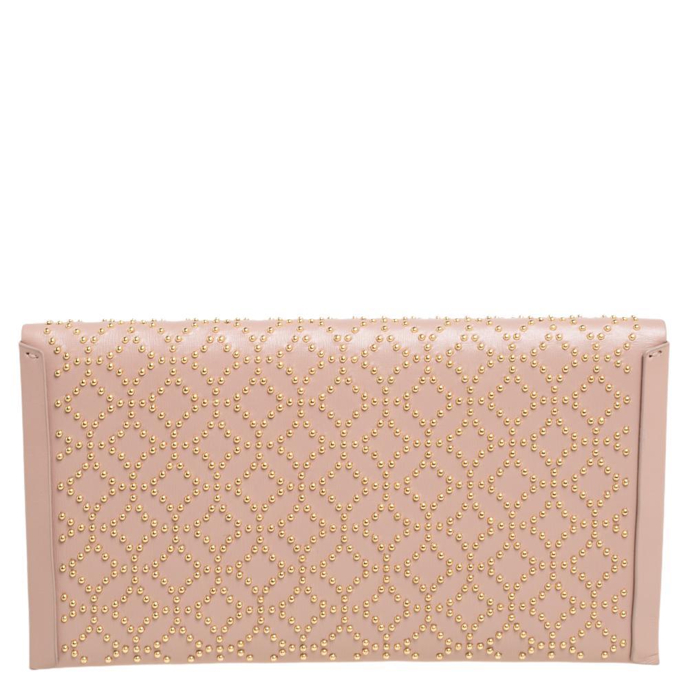 Made in Italy, and shining with beauty is this beautiful envelope clutch by Alaia. It has been crafted from leather and carries the shape of an envelope. The pink clutch has stud embellishments throughout. This well-made creation deserves to be