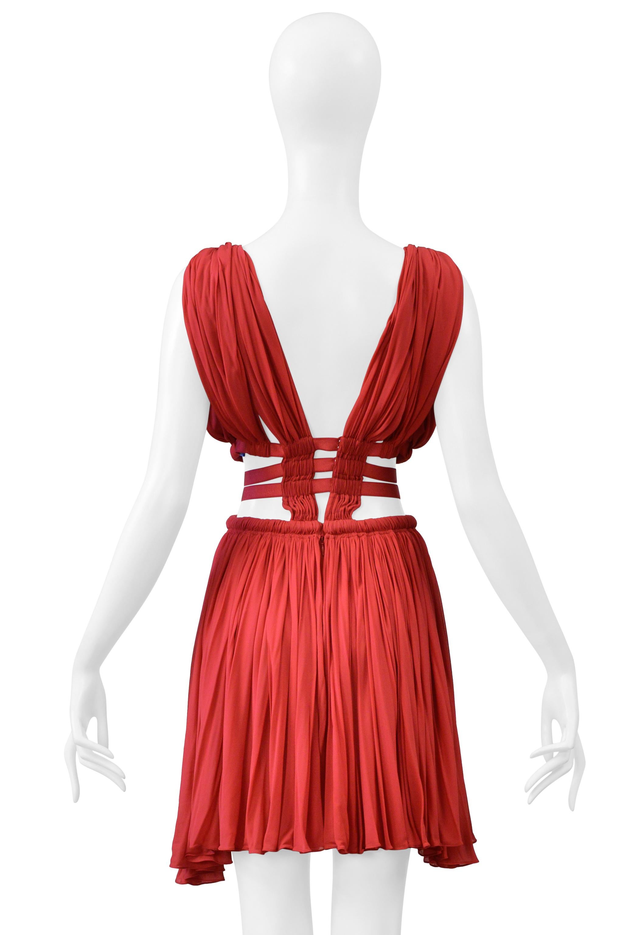 Resurrection Vintage freut sich, ein originales Azzedine Alaia Minikleid aus rotem Jersey anbieten zu können. Es hat einen tiefen Ausschnitt, gesmokte Details an der Taille, seitliche Leiterausschnitte, Haken- und Ösen-Schnappverschlüsse am Rücken,