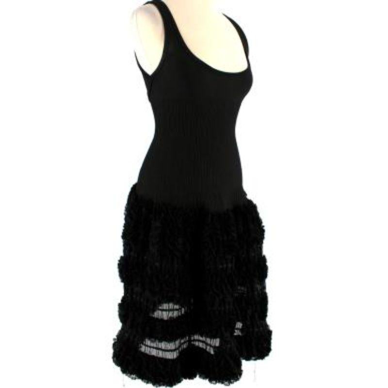 Alaia Ruffled Sleeveless Black Knit Skater Dress

- Mid weight
- Oversized sheer ruffle mini skirt 
- Slim fitting top 
- Deep cut neckline 
- Back zip fastening

Materials:
Silk and polyester blend 

Made in italy 

Dry clean only

PLEASE NOTE,