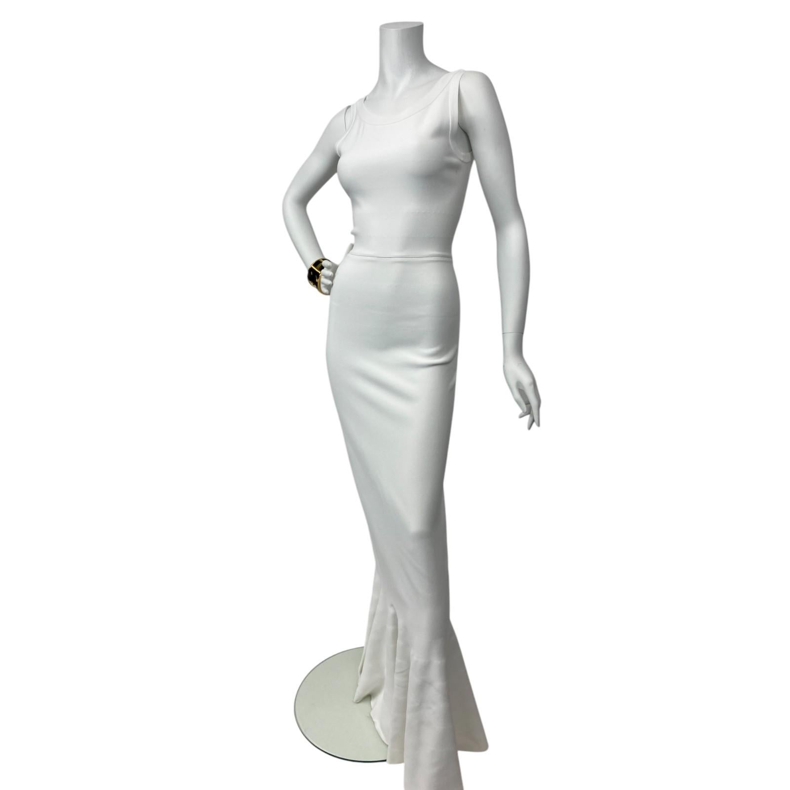 Zeitlos, skulptural und unverkennbar Alaïa, zeigt dieses weiße Meerjungfrauenkleid die legendäre Beherrschung der Form und des Stoffes durch den Designer. Das Kleid ist aus luxuriösem, schwerem Crêpe gefertigt und zeichnet sich durch einen