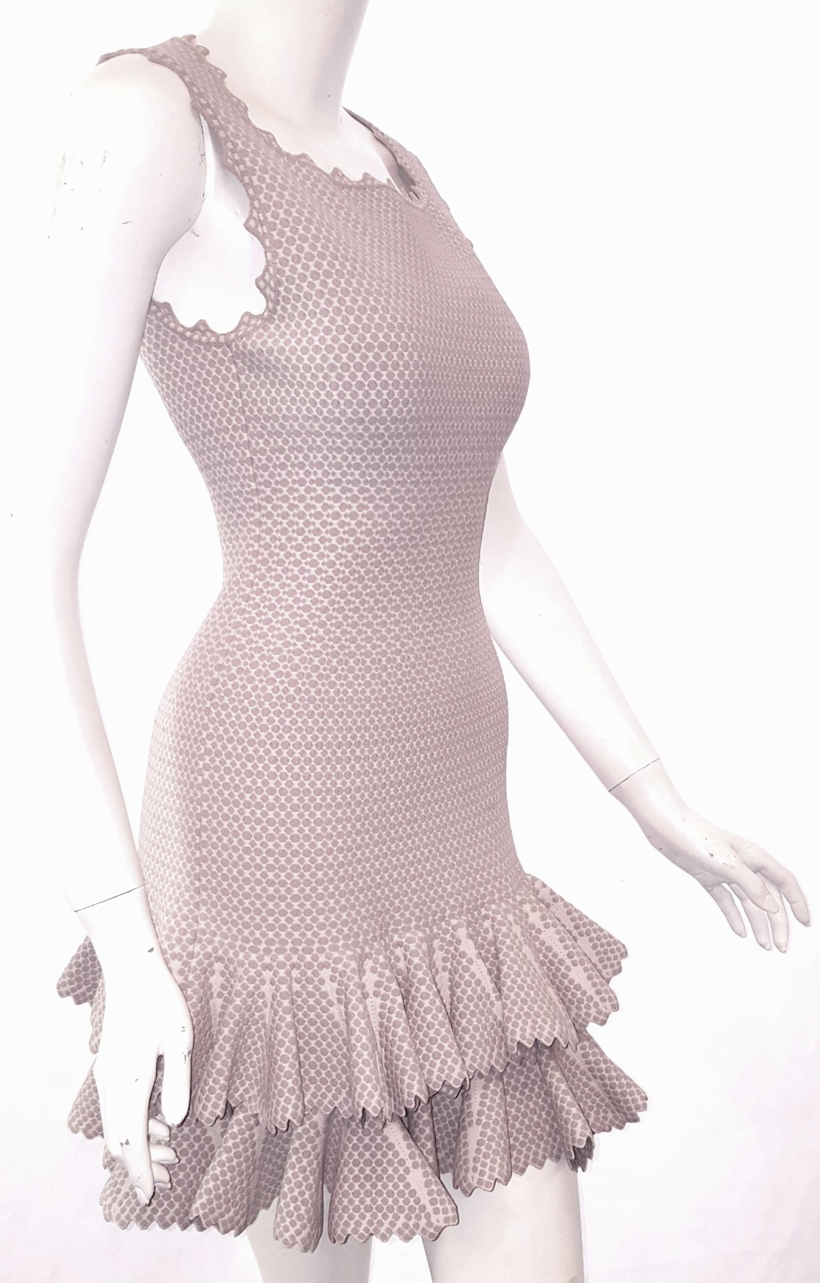 Alaïa is the choice of women for body conscious and enhancing garments.  This sleeveless, two tier ruffle dress is feminine yet sexy at the same time.  Elongated dropped waist is accentuated by a square neckline with zig-zag trim all around