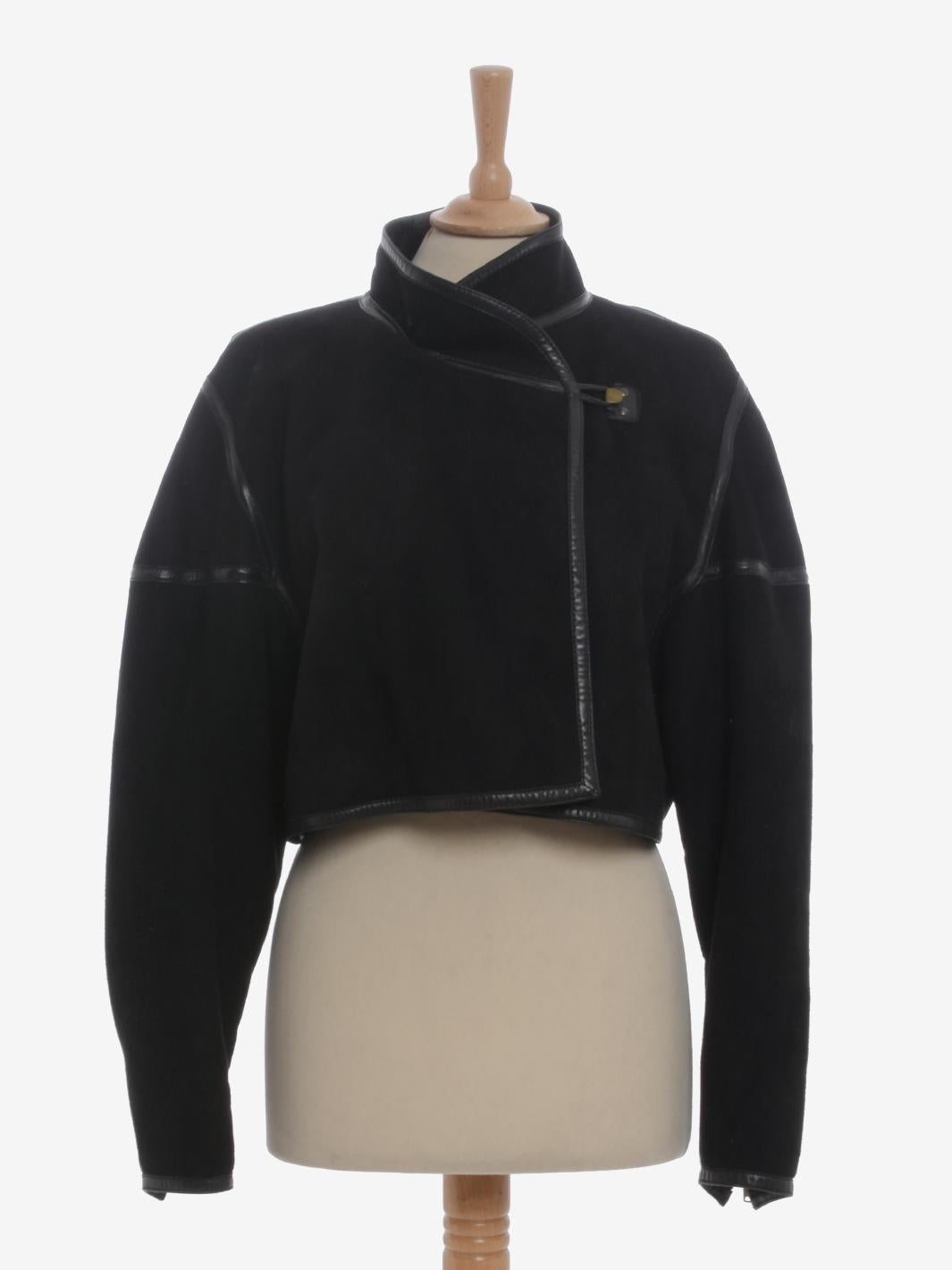 Alaïa Shearling Bolero is a rare longuette made by Azzedine Alaïa in the second half of 1980s featuring asymmetrical frog closure, high collar, and shiny leather details that create geometric lines throughout the garment accentuating the shapes of