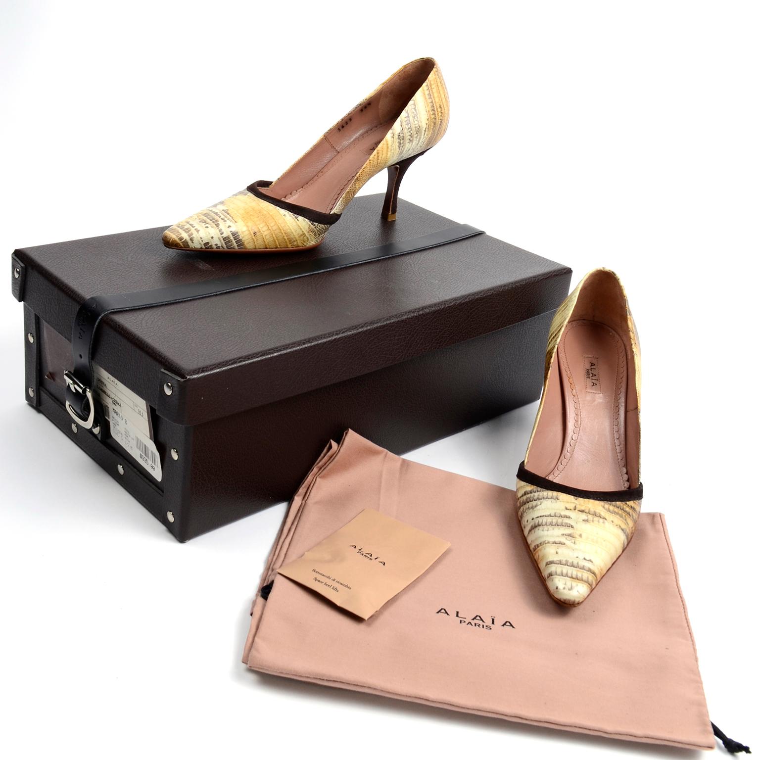 Diese Alaïa Schlangenleder-Pumps sind in einer schönen Cremefarbe mit braunen Wildlederabsätzen und -besätzen. Die Modellnummer für diese Schuhe ist: AAP434-6PT Tejus 80mm Pumpe. Diese Schuhe kommen in Originalverpackung, die aus Leder mit einer