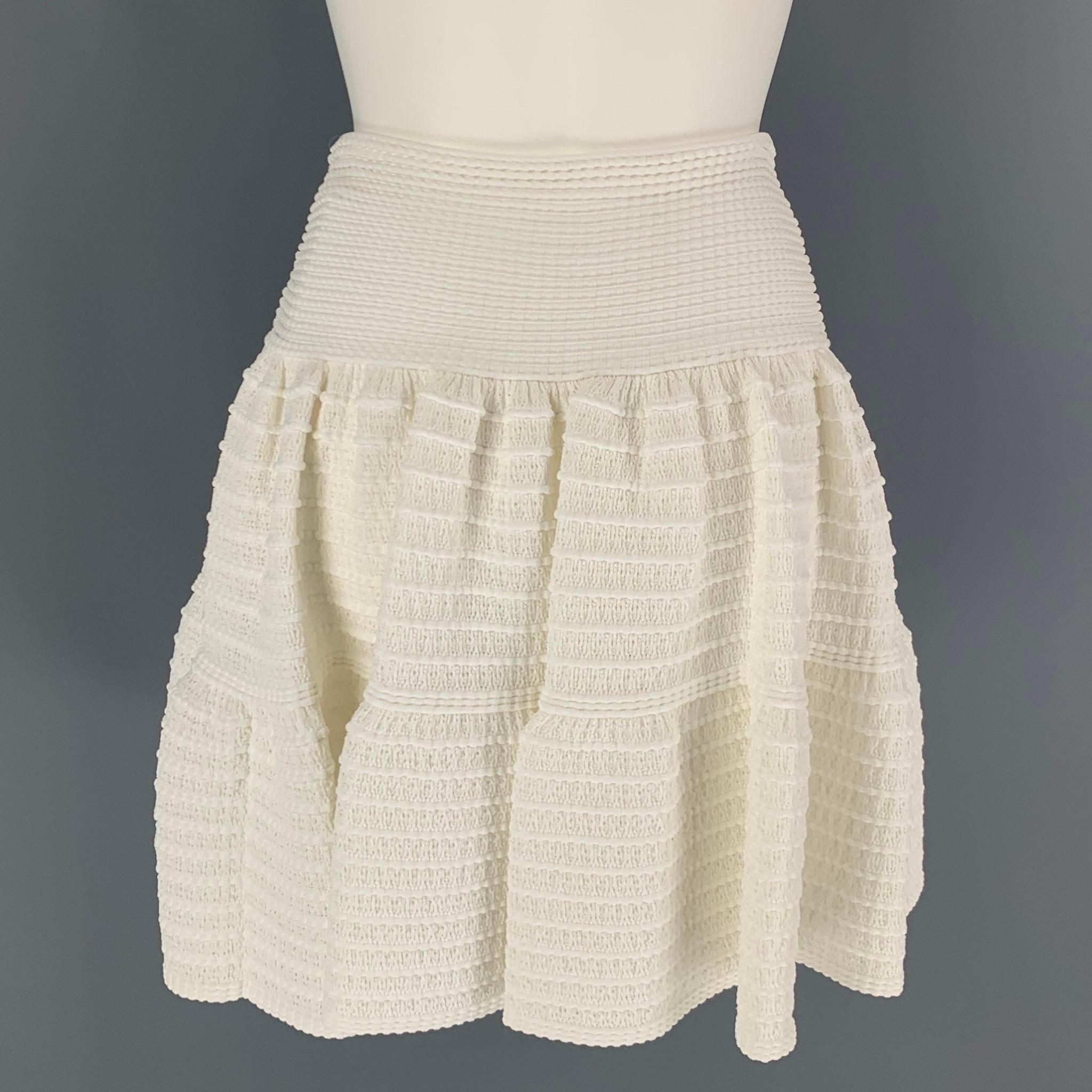 ALAIA skirt comes in a white knitted textured stretch cotton blend featuring a circle style and a elastic waist. Made in Italy. 

Very Good Pre-Owned Condition.
Marked: 38

Measurements:

Waist: 24 in.
Hip: 38 in.
Length: 19 in.