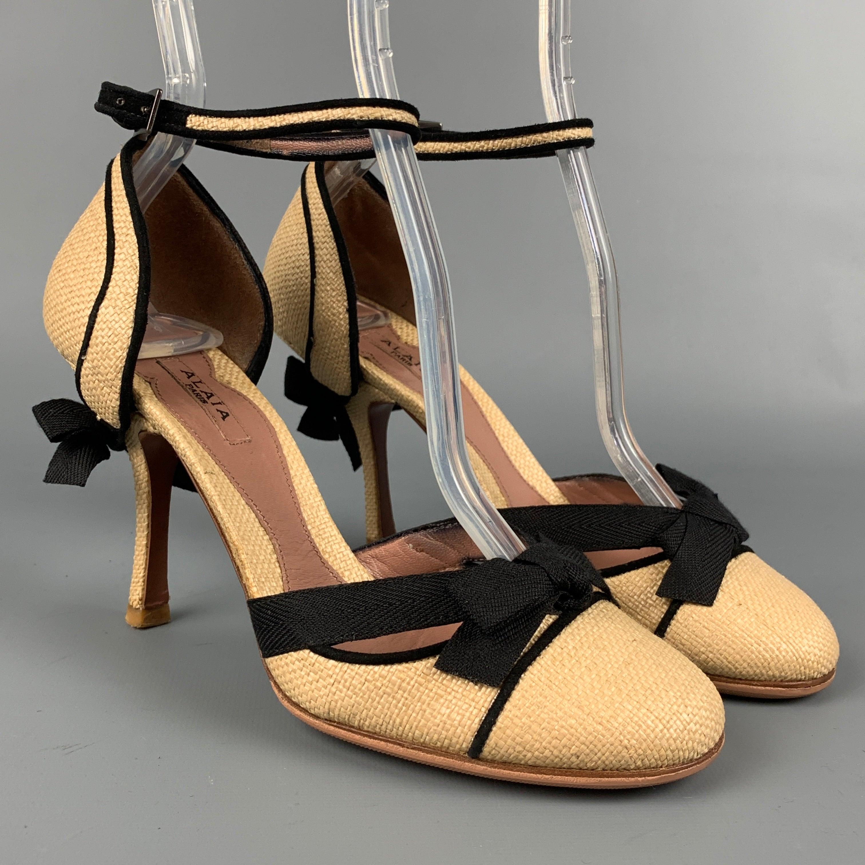 ALAIA pumps comes in a natural straw material with a black trim featuring a bow detail, ankle strap, and a stacked heel. Made in Italy. Very Good
 Pre-Owned Condition. 
 

 Marked:  35.5 
 

 Measurements: 
  Heel: 3.5 inches 
  
  
  
 Sui Generis