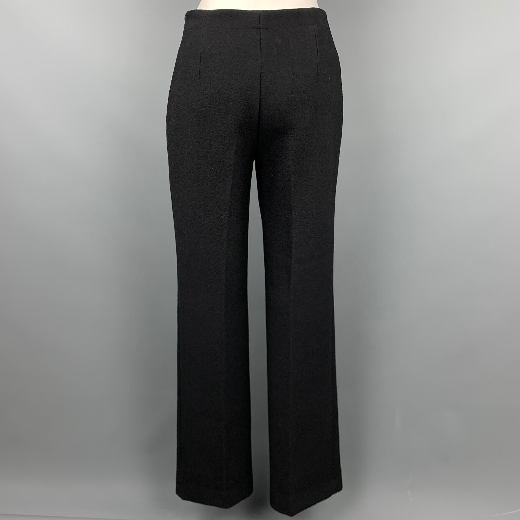 ALAIA dress pants in a heavy wool canvas fabric featuring a streamline, minimalist construction, flat front, straight leg, and side zip closure. Made in Italy.

Excellent Pre-Owned Condition.
Marked: 38

Measurements:

Waist: 28 In.
Rise: 10