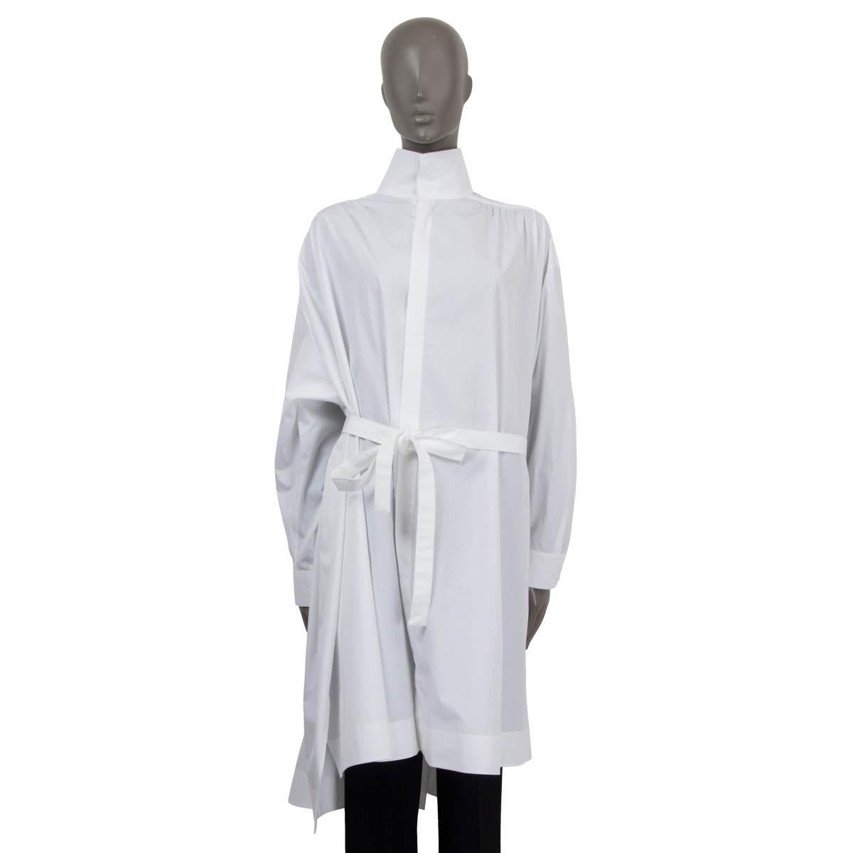 100% authentic Alaia oversized poplin blouse in white cotton (100%). Features a full back slit, a detachable belt and a high neck. Has long sleeves, drop shoulders and buttoned cuffs. Opens with buttons on the front. Unlined. Has been worn and is in