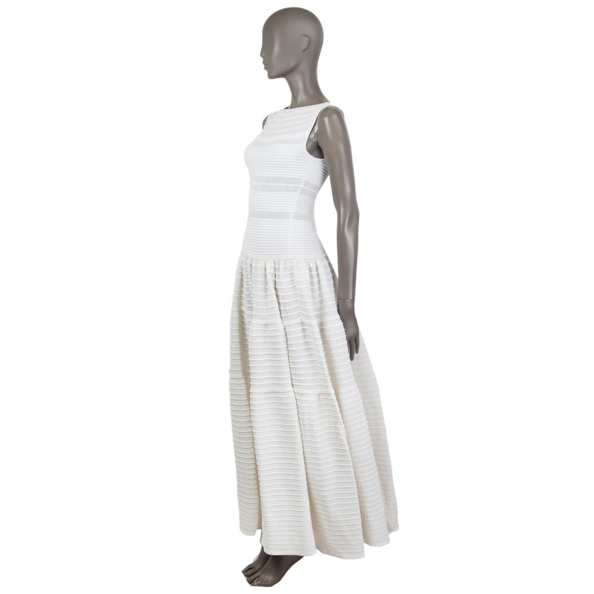 Alaïa sleeveless fit-to-flare knit dress in white and off-white cotton (40%), viscose (35%), nylon (15%) and polyester (10%) with a round neck. Closes on the side with a concealed zipper. Unlined and partially sheer. Fabric has come slightly undone