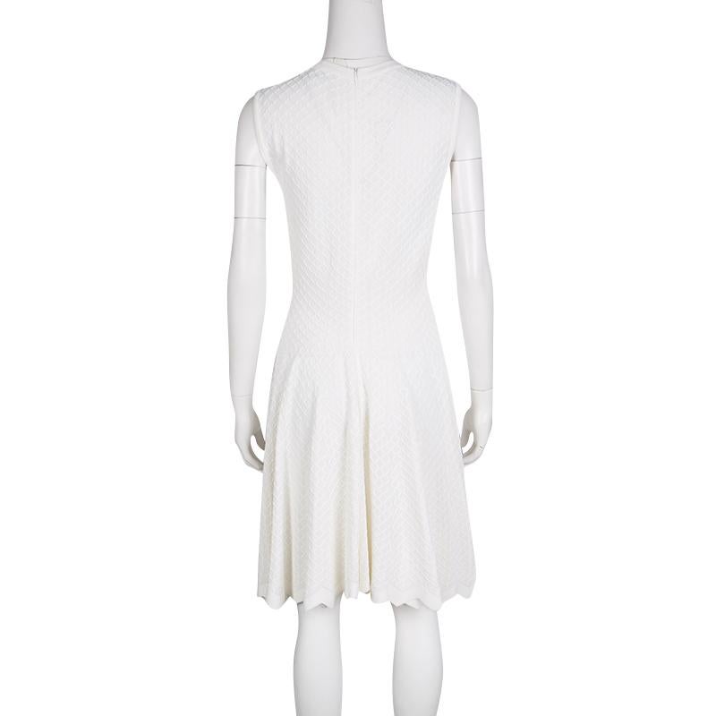 How pretty is this dress from Alaia! It has been created from the finest materials and designed in white with a back zipper and a chevron-cut hem. The dress has a fit and flare style, with a fitted waistline and a flared skirt.


