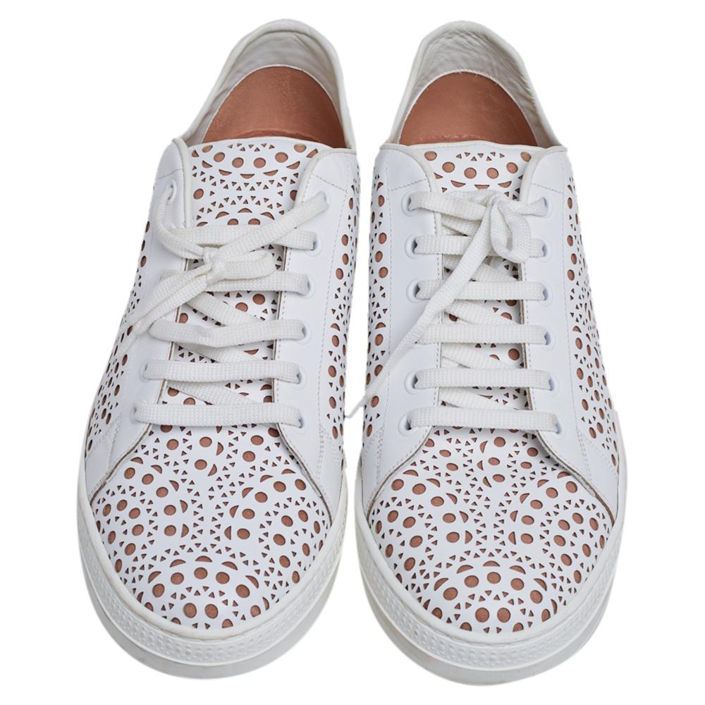 These stylish Alaia sneakers are meant to deliver signature looks every time. Crafted from white laser-cut leather, they feature round toes and lace-ups on the vamps. They are complete with comfortable leather-lined insoles and durable rubber