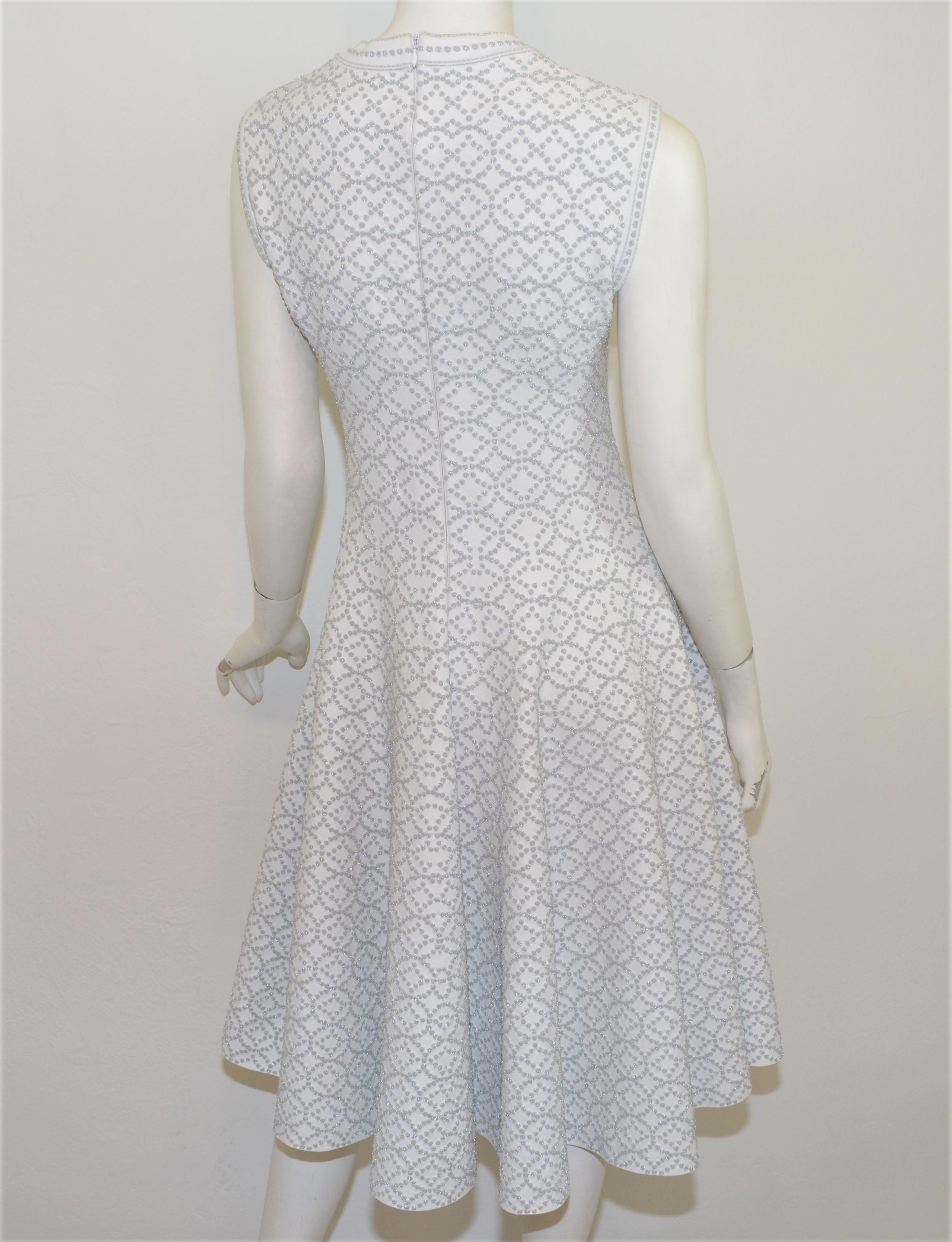 Alaia Passform und Streulicht Kleid in weiß mit metallischen Silber Fäden in der gesamten mit einer Passform und Streulicht Design vorgestellt. Das Kleid wird mit einem Reißverschluss am Rücken geschlossen und ist mit Größe 42 etikettiert.