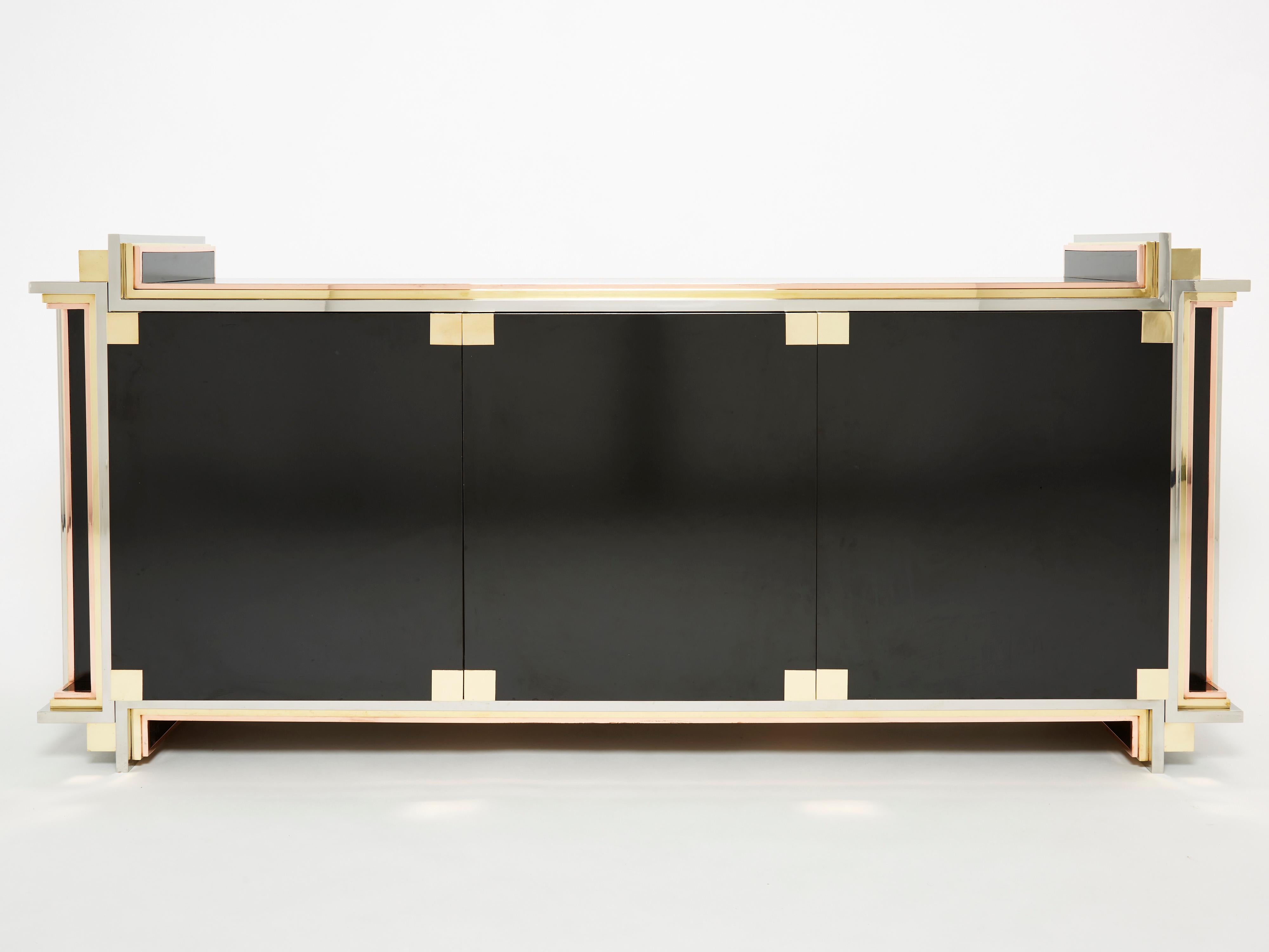 A unique and timeless vintage piece, this mid-century sideboard feels imposing and glamourous, with straight lines of brass copper and chrome adorning its exterior of reflective black lacquer. It was designed by Alain Delon and edited by Maison