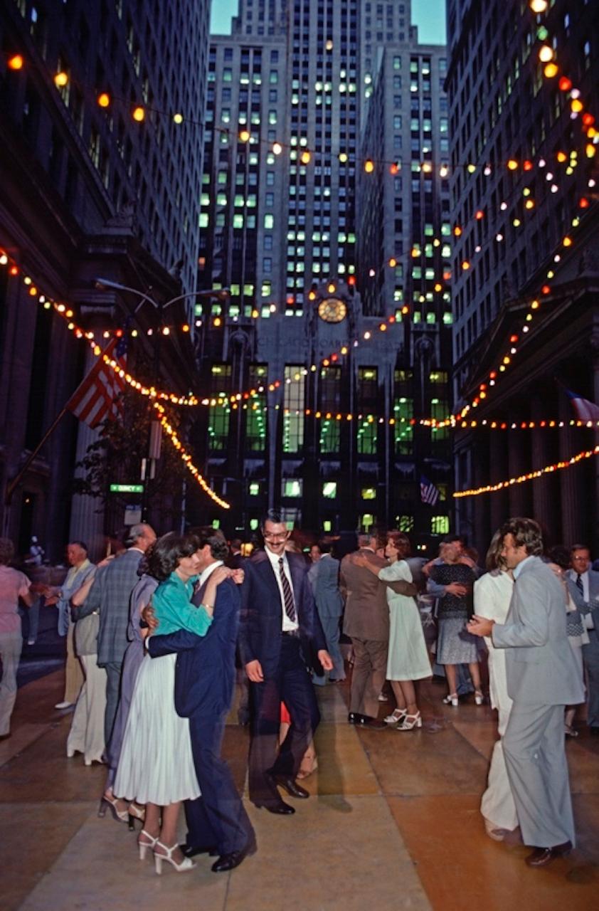 Dancing Partners by Alain Le Garsmeur
People dance under stringed lights outside the Chicago Board of Trade during a Dinner and Dance evening, Chicago, Illinois, USA, 1979.

Paper size 24 x 20 inches / 60 x 50 cm
Printed in 2022 - produced from the