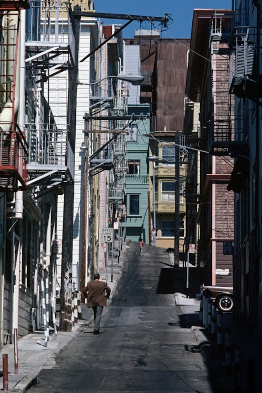 San Francisco Escapes by Alain Le Garsmeur
A man walks under fire escapes on the streets of San Francisco, California, 1979.

Paper size 40 x 30 inches / 101 x 76 cm   
Printed in 2022 - produced from the original transparency
Archival Pigment Print