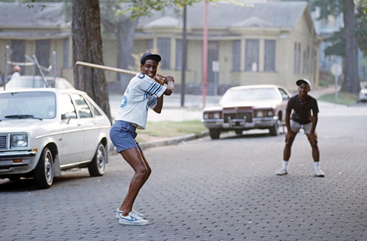 Savannah Strike by Alain Le Garsmeur
Group of men having fun playing baseball in the street in downtown Savannah, Georgia, USA, 1983.

Paper size 16 x 20 inches / 40 x 50 cm 
Printed in 2022 - produced from the original transparency
Archival Pigment
