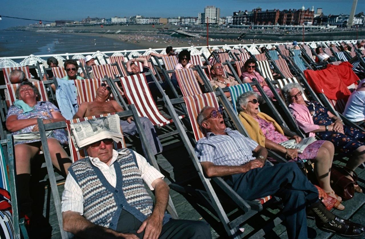 Soaking Up The Sun by Alain Le Garsmeur
Elderly sunbathers soaking up the sun in rows of deckchairs on Blackpool beach, England, 1981. 

Paper size 20 x 30 inches / 50 x 76 cm
Printed in 2022 - produced from the original transparency
Archival