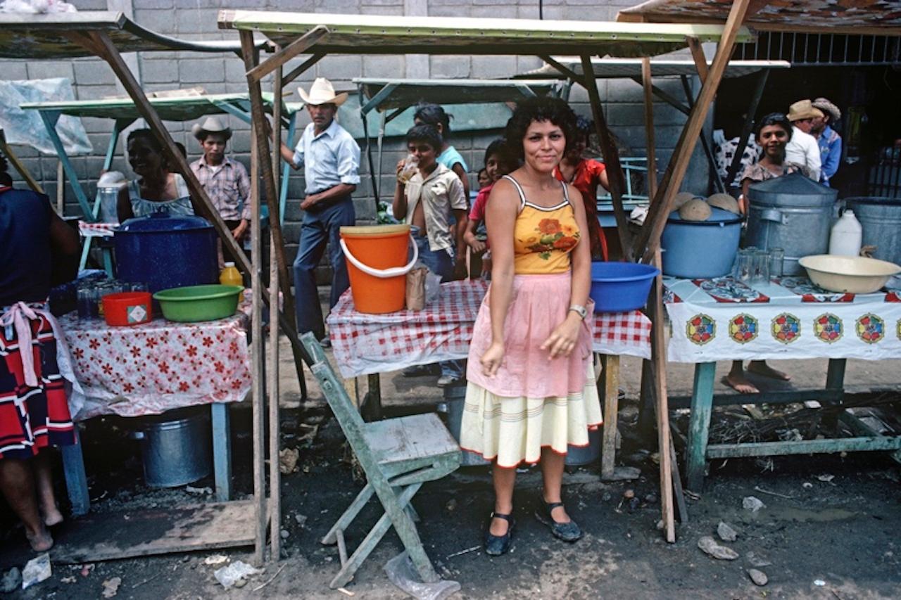 Straßenstand von Alain Le Garsmeur
Eine Frau steht an ihrem Stand auf einem Straßenmarkt, Tegucigalpa, Honduras, Mittelamerika, 1981.

Papierformat 16 x 20 Zoll / 40 x 50 cm 
Gedruckt im Jahr 2022 - hergestellt von der Originalfolie
Archival Pigment