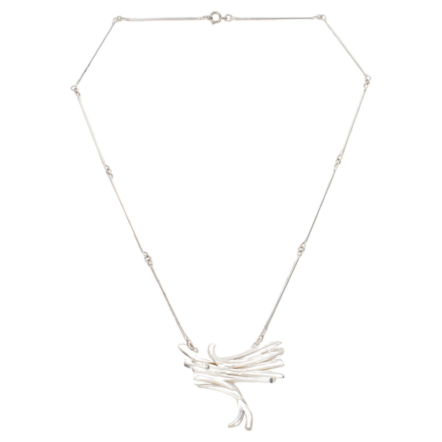 Questa splendida collana a girocollo dell'artista francese Alain Lerolle presenta una forma brutalista e modernista non strutturata con un pendente intagliato e dimensionale in metallo argentato. Il pezzo è firmato sul lato inferiore con il marchio