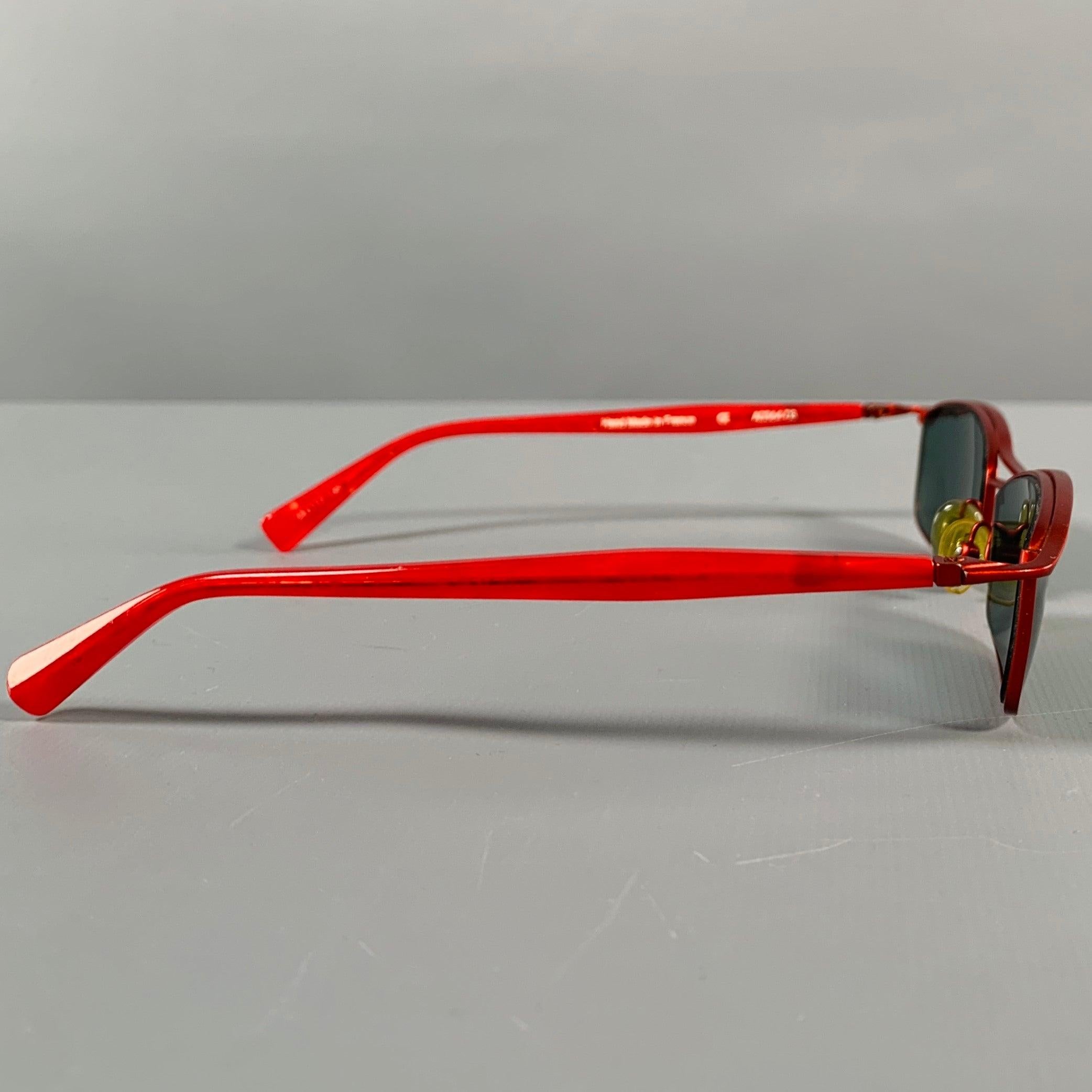 ALAIN MIKLI sunglasses in a red metal featuring a rectangular shape. Comes with case. Handmade in France.Excellent Pre-Owned Condition. 

Marked:   A0364-03 

Measurements: 
  Frame Width: 14 cm.Frame Height: 2.5 cm.
  
  
 
Sui Generis Reference: