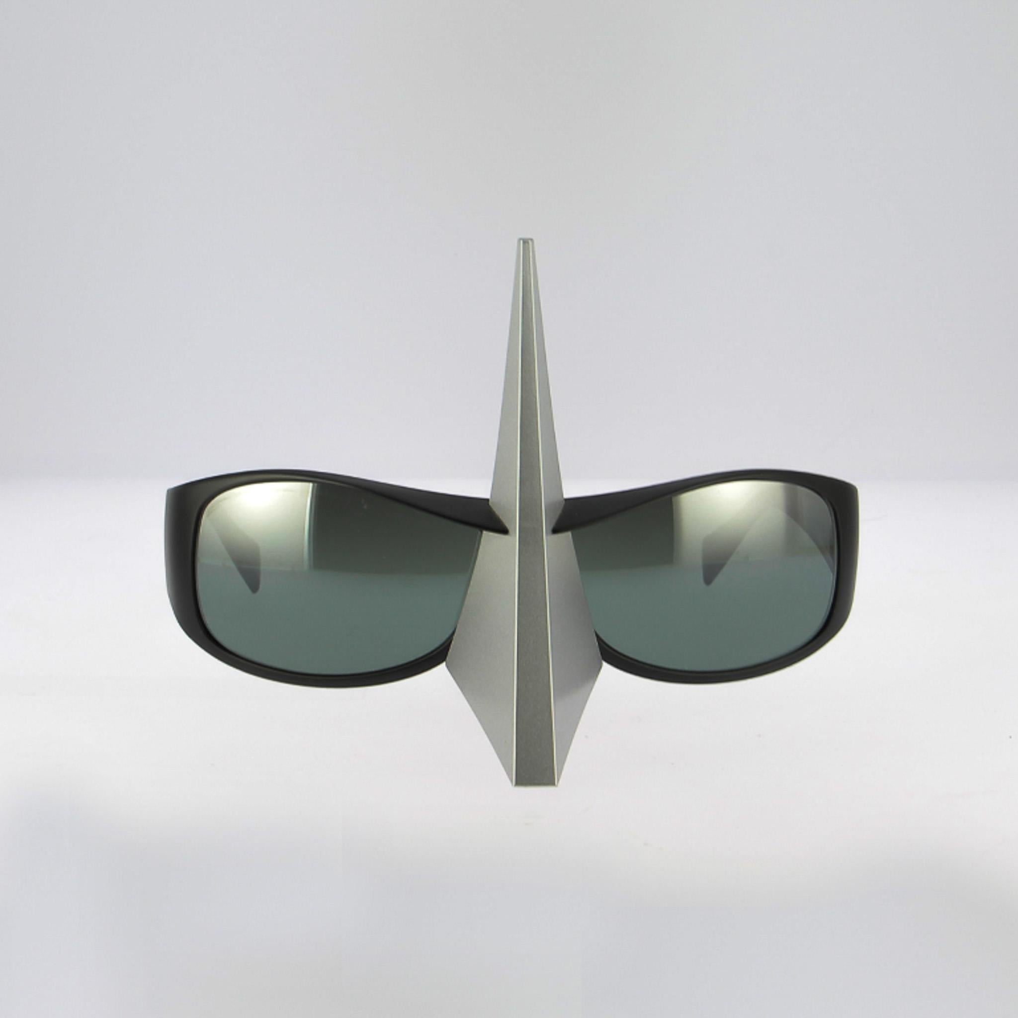 Questa ristampa di Alain Mikli incarna perfettamente lo spirito avanguardista della casa francese.  designer, un vero e proprio pioniere dell'occhialeria degli anni '80 e '90. Fedele alla sua filosofia del design come scultura, questa cornice osa