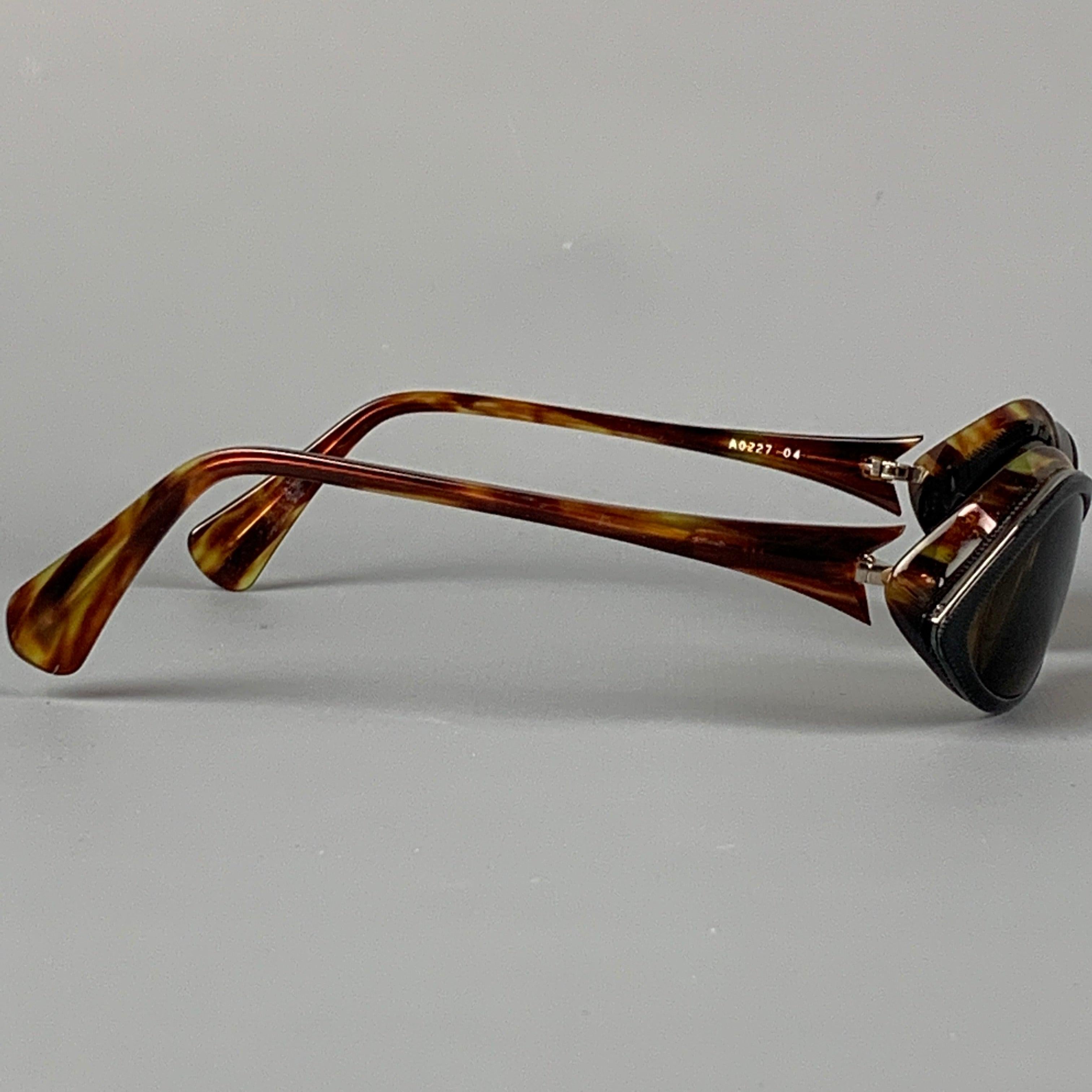 ALAIN MIKLI sunglasses comes in a tortoise shell acetate featuring a black trim and tinted lenses. Made in France.
 Good
 Pre-Owned Condition. 
 

 Marked:  A0227 04 
 

 Measurements: 
  Length: 12 cm. Height: 4 cm.
  
  
  
 Sui Generis Reference: