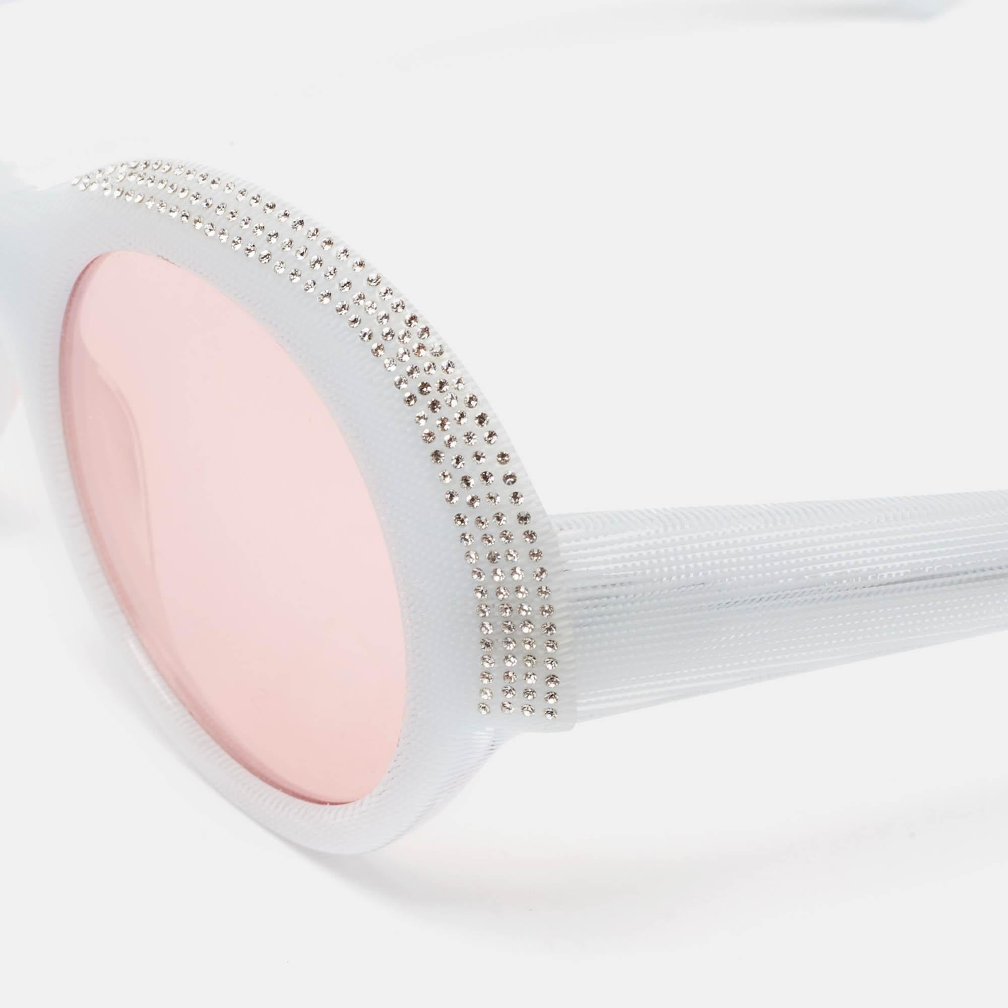 Questi occhiali da sole rotondi Alain Mikli x Alexandre Vauthier fondono glamour e arte con la loro straordinaria montatura a sfumature chiare e i cristalli rosa Roselyn scintillanti. Perfetta per aggiungere un tocco di classe a qualsiasi